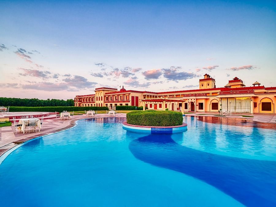 day time view of crystal blue waters in a pool with resort in the background - The Ummed Jodhpur, Palace Resort and Spa3