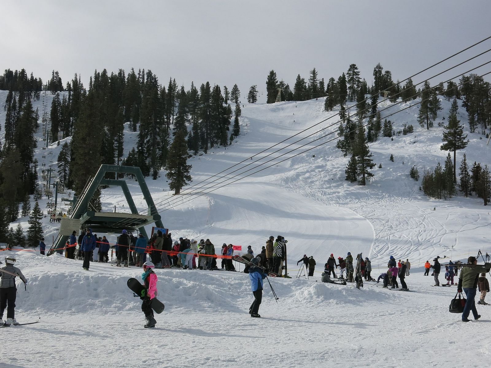 People skiing on a snowy mountain on an overcast day.