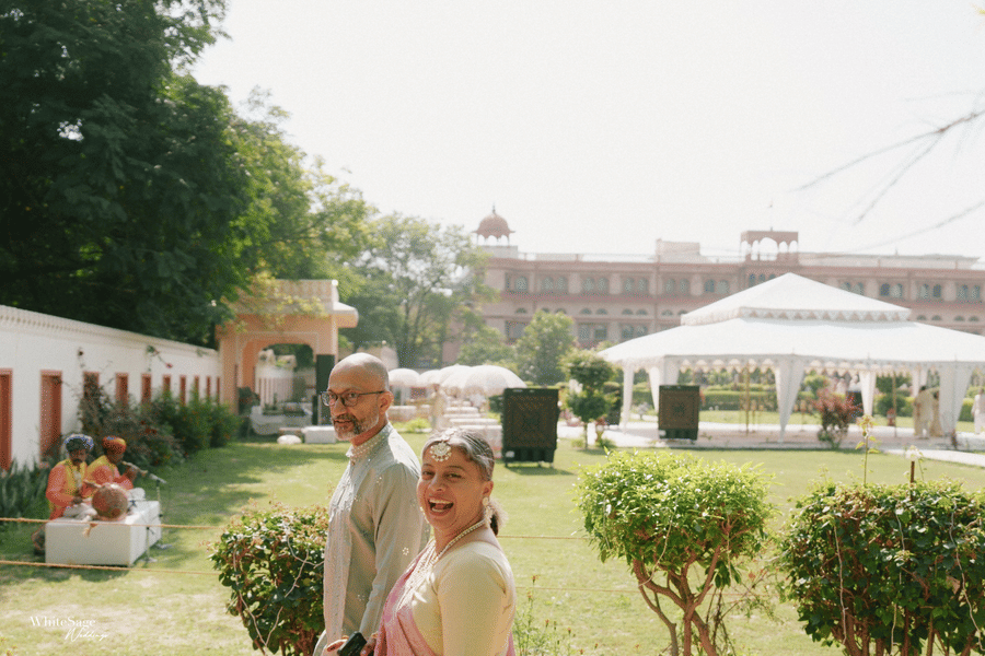 Guests walking across a green lawn with a white tent structure in the background at Maid Palace.