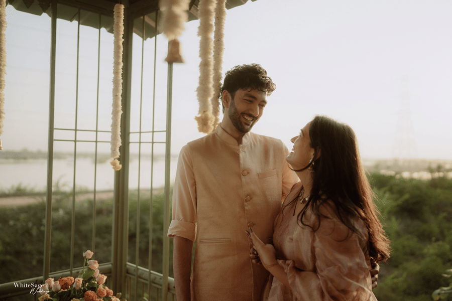 Smiling couple posing under an open-air garden gazebo during pre-wedding festivities at Umaid Palace.