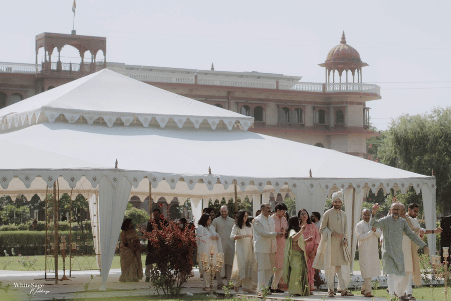 Guests gathered around a white marquee tent setup on the lawn at Umaid Palace.