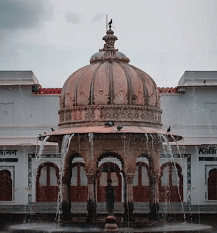  Dome structure with water feature, overcast sky.