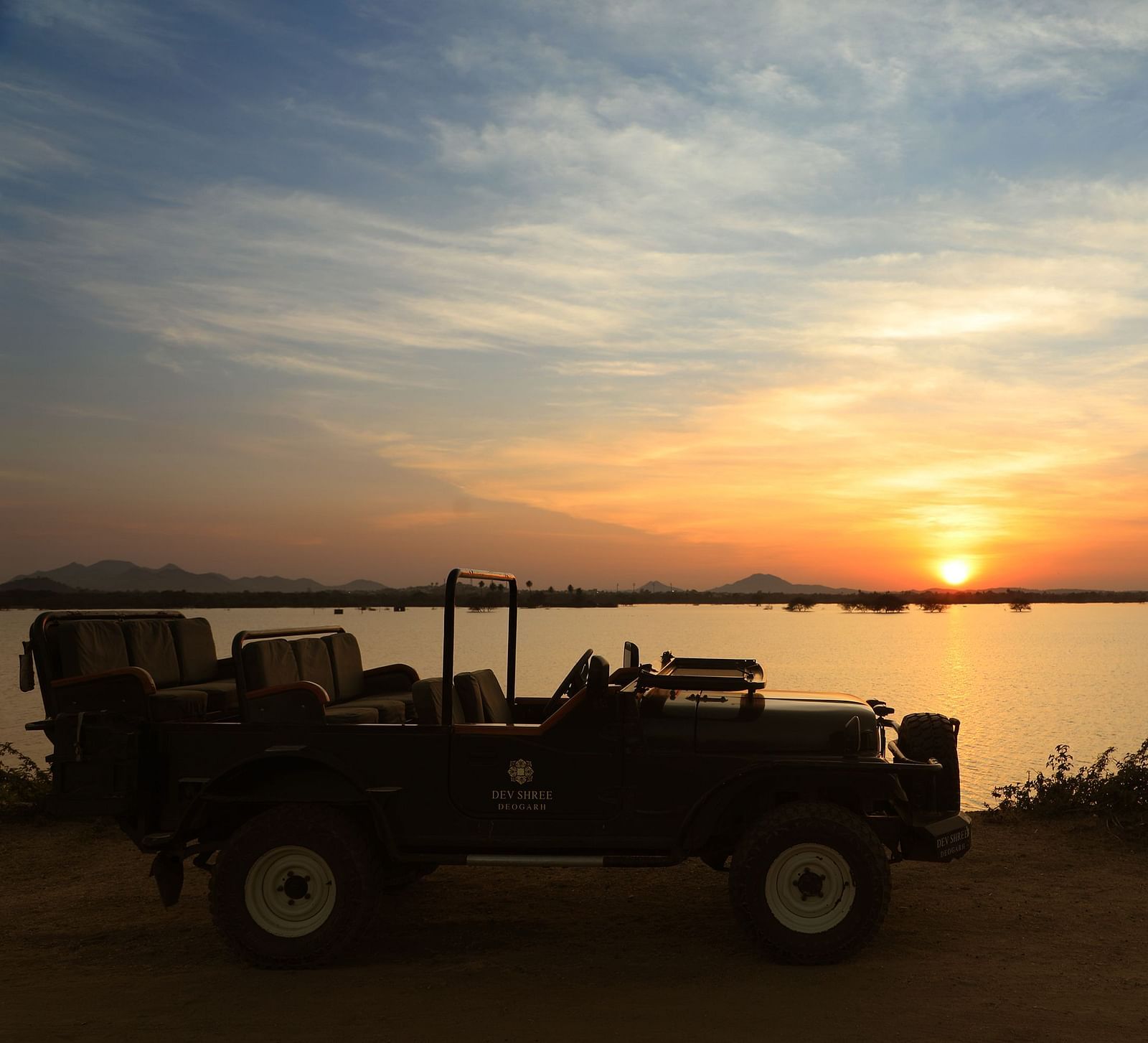 an image of a jeep with a beautiful sunset background at dev shree, deogarh