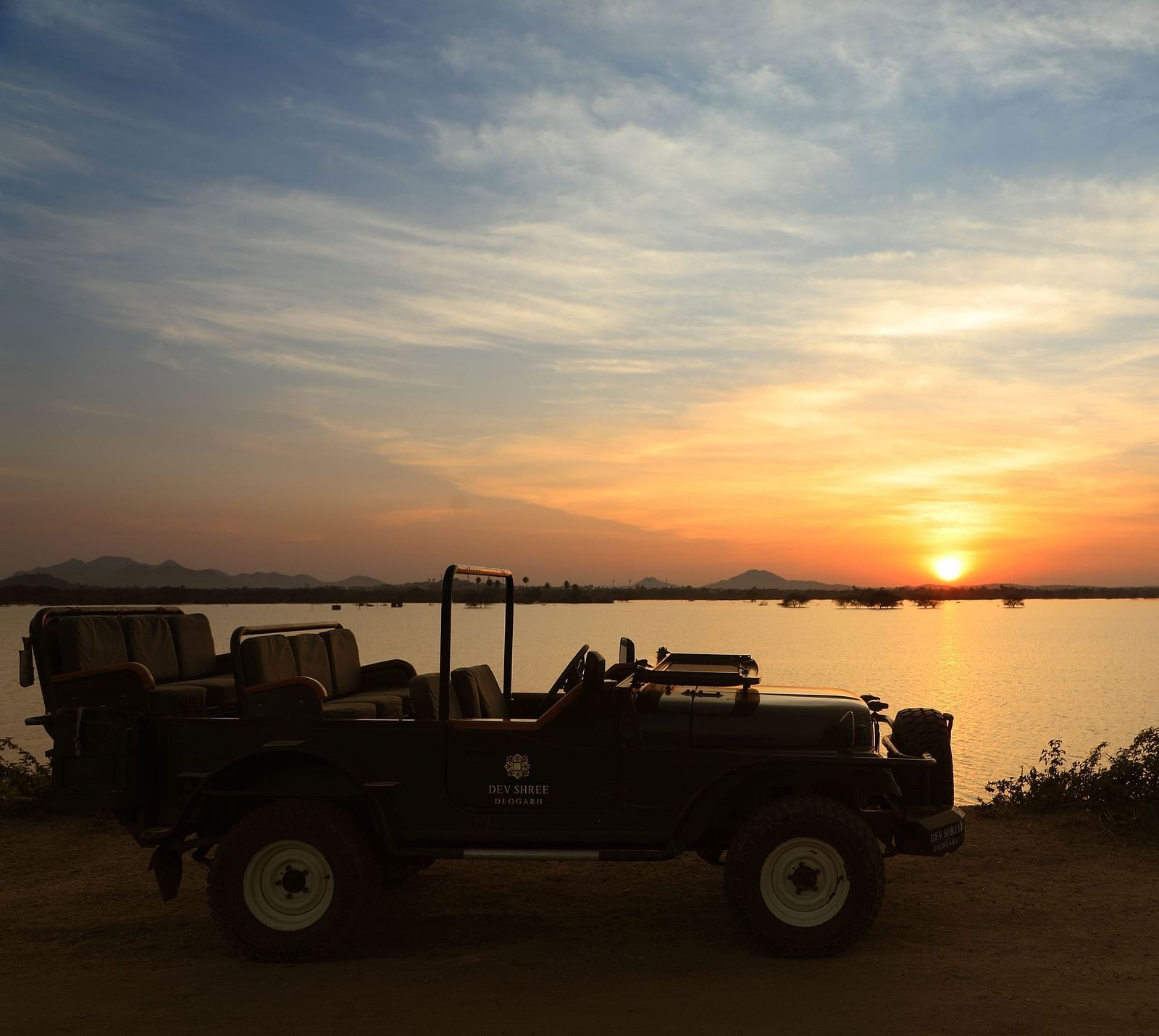 an image of a jeep with sunset in the background at dev shree, deogarh