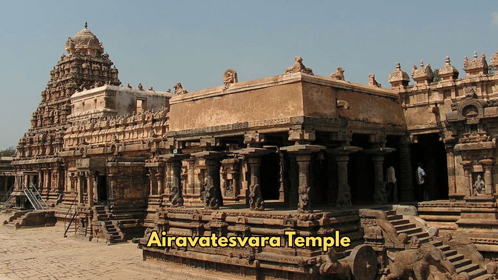 Stone structures form the complex of Airavatesvara Temple. Pillars line the front porch, and a tower rises at the rear.