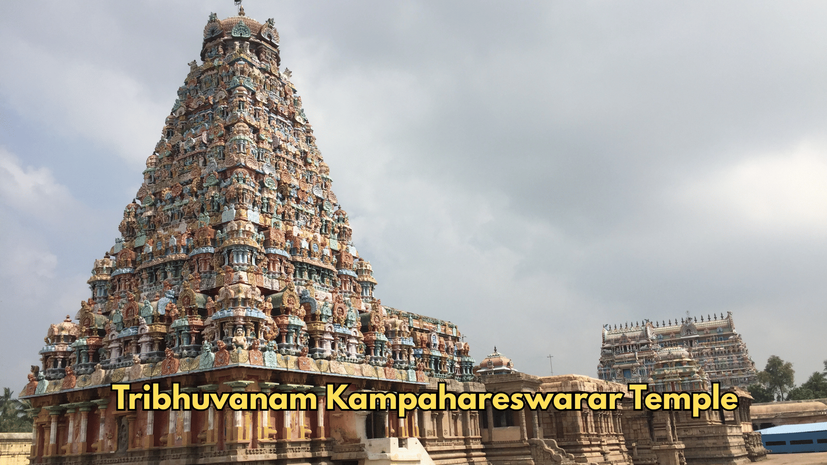 The tower of Tribhuvanam Kampahareswarar Temple rises toward the sky. Sculptures cover the tiers of the structure.