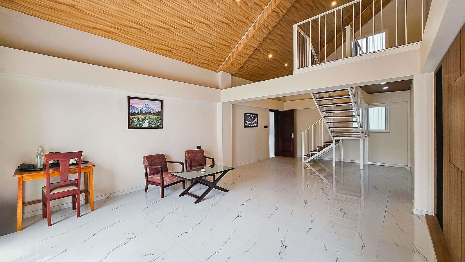 A spacious, open-plan living area with high, sloped wooden ceilings and a seating arrangement, showcasing the interior of Yashshree Resorts & Spa, Kalimpong.