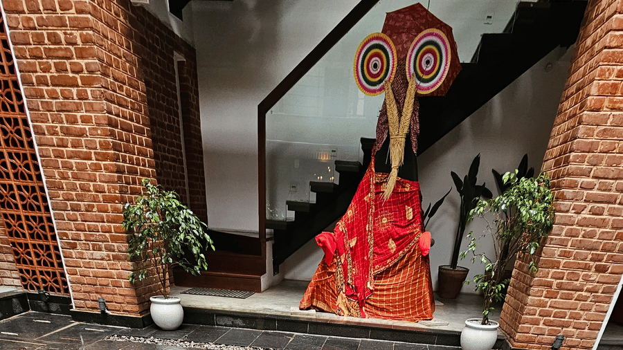 A large, circular brass mandala medallion set into the dark slate flooring of an upscale heritage hotel lobby in Bhaktapur, Nepal.