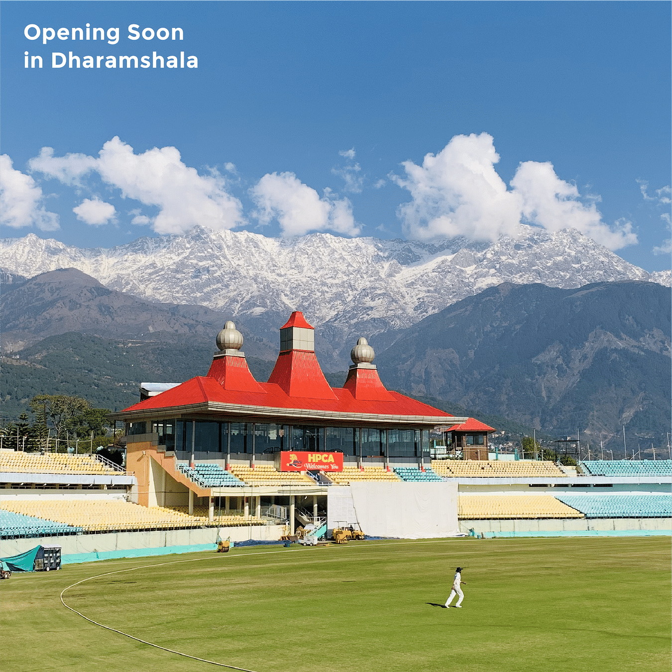 A picturesque image of stadium as the mountain are standing in the background with their heads covered with clouds