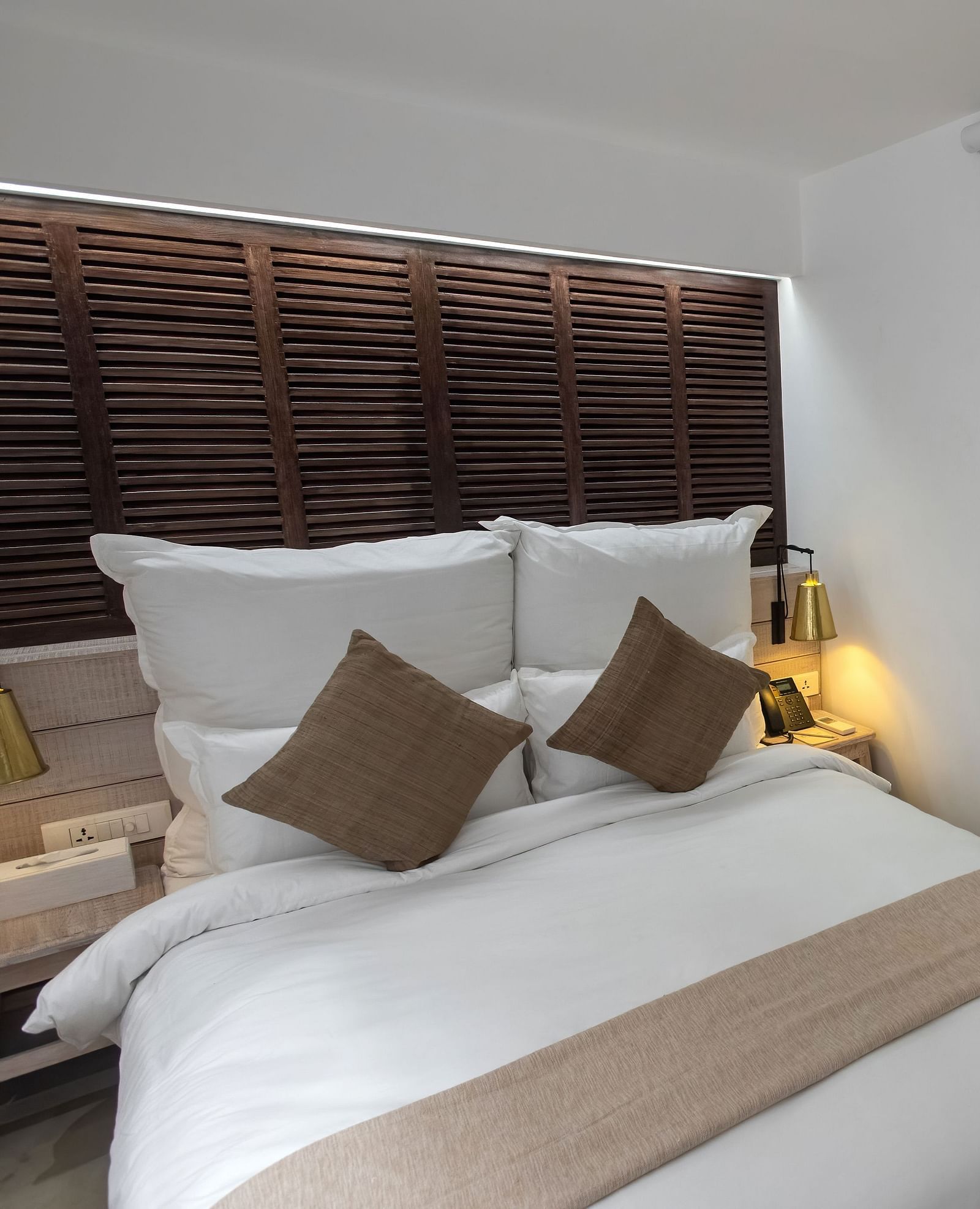 Standard room with a bed, bed side table, lamps and the washroom area - The Nanee