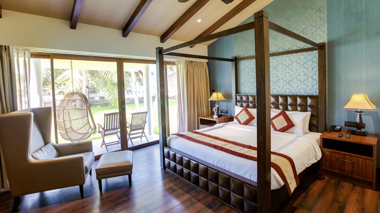 A suite with a double bed, sofa, and windows | MGM Hotels & Resorts