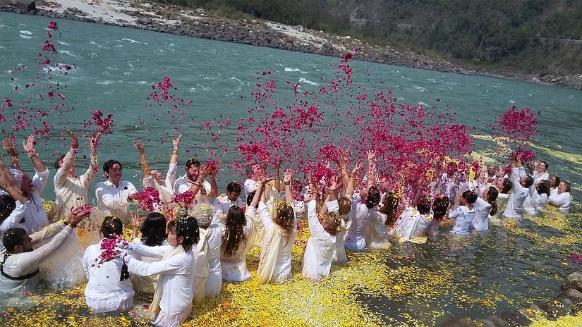 Visitors playing with flower petals in the Ganges