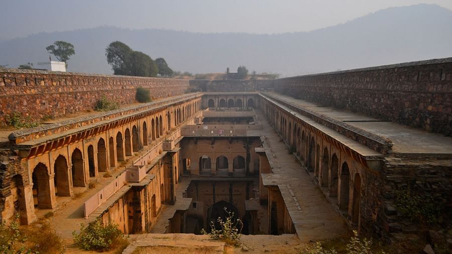 An overview of a stepwell in Rajasthan with a mountain in the background.