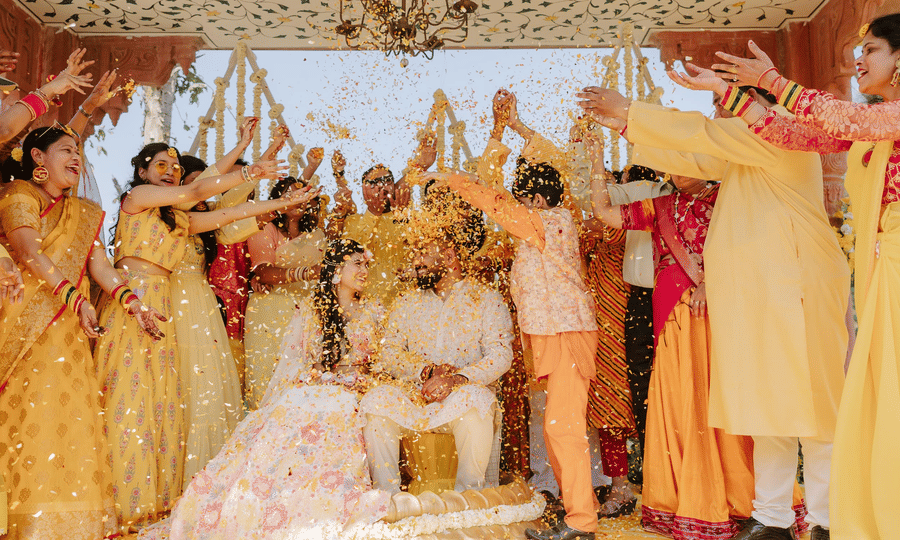 Family and friends celebrating a joyful haldi ceremony with the couple at Umaid Palace.