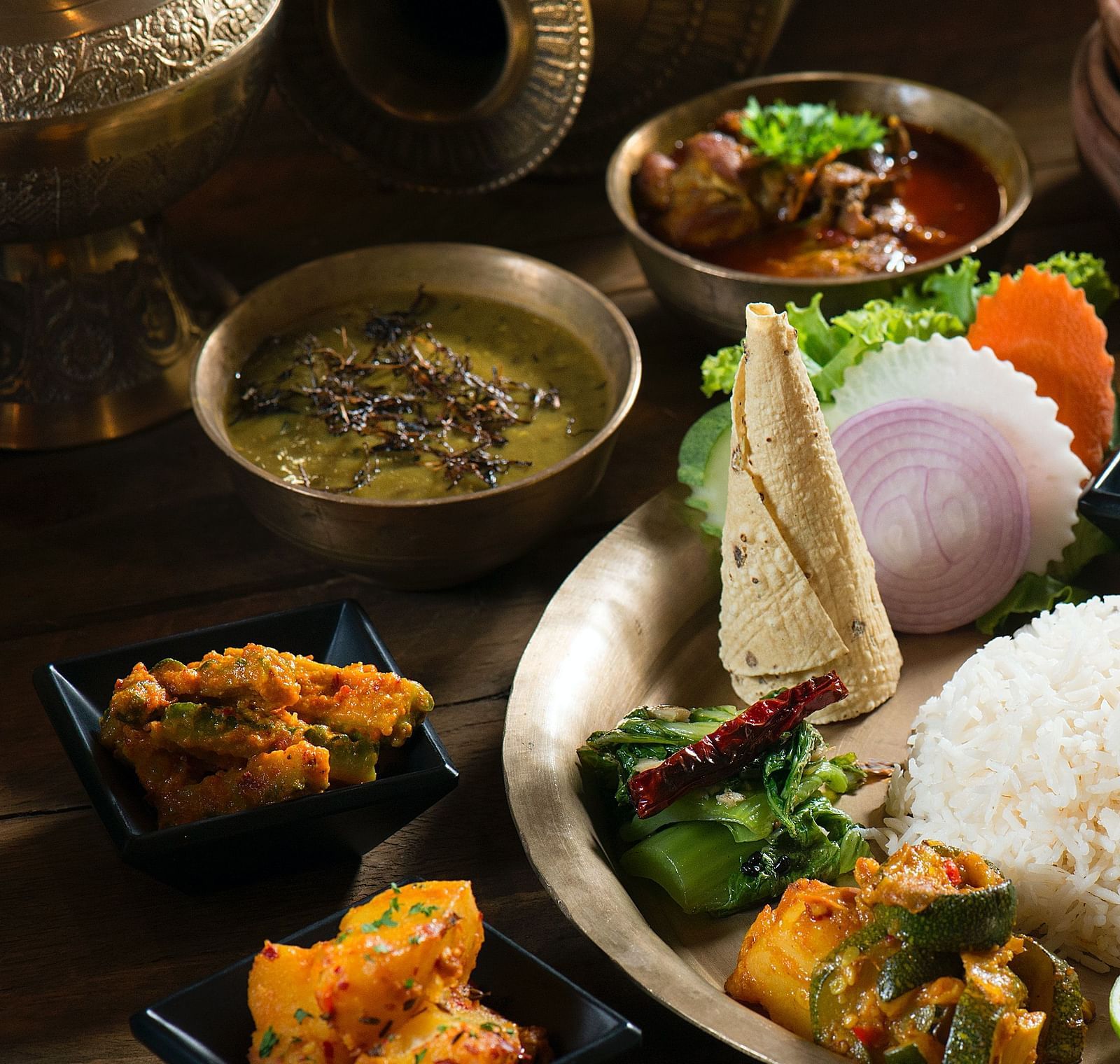 an authentic nepali thali with rice dal papad curries garnished with lemon and chilli pyobcm