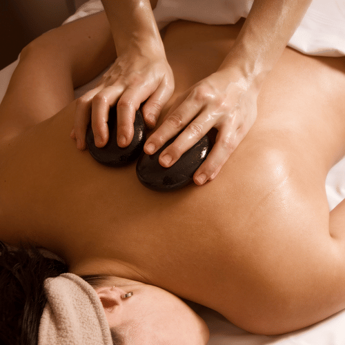 A person getting a hot stone massage while lying on her stomach at YO1 Longevity & Health Resort