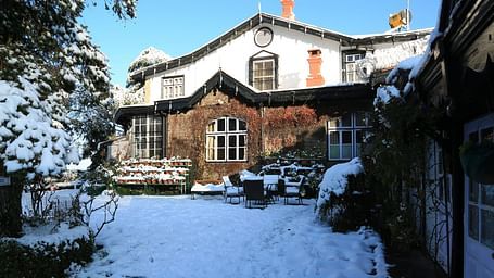 A facade image of Chapslee Hotel covered in snow during a sunrise