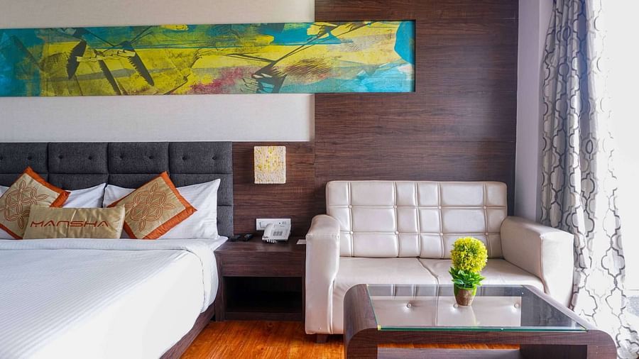 A room at Mansha Hotel Regency featuring a bed, a bedside table, a sofa, and a coffee table.