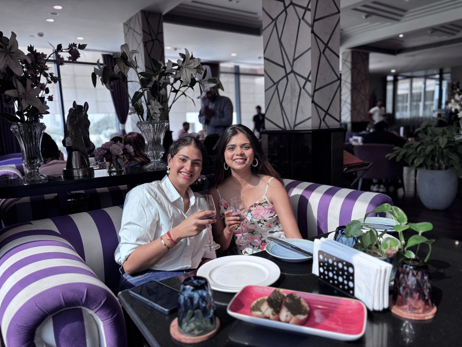Two people sitting on a couch with a party setup at Karma Lakelands
