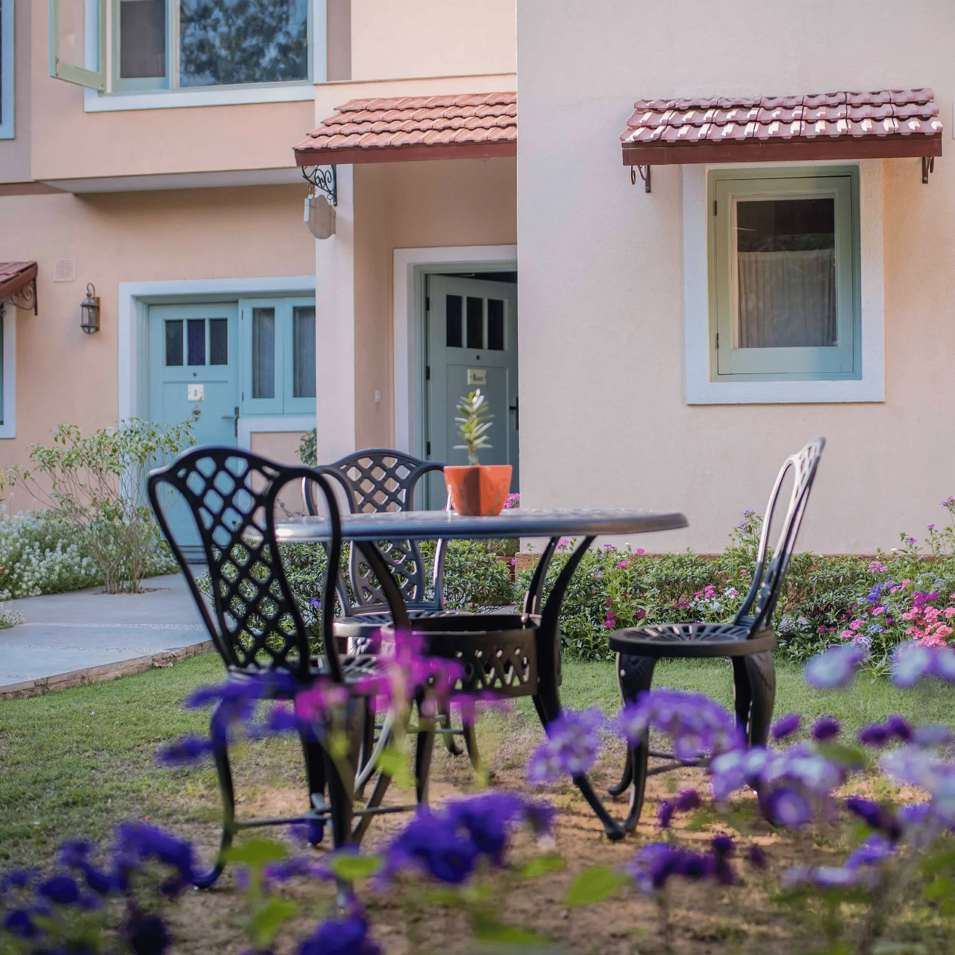 Outdoor patio at Karma Chalets with two black chairs and a round table near the building’s entrance.