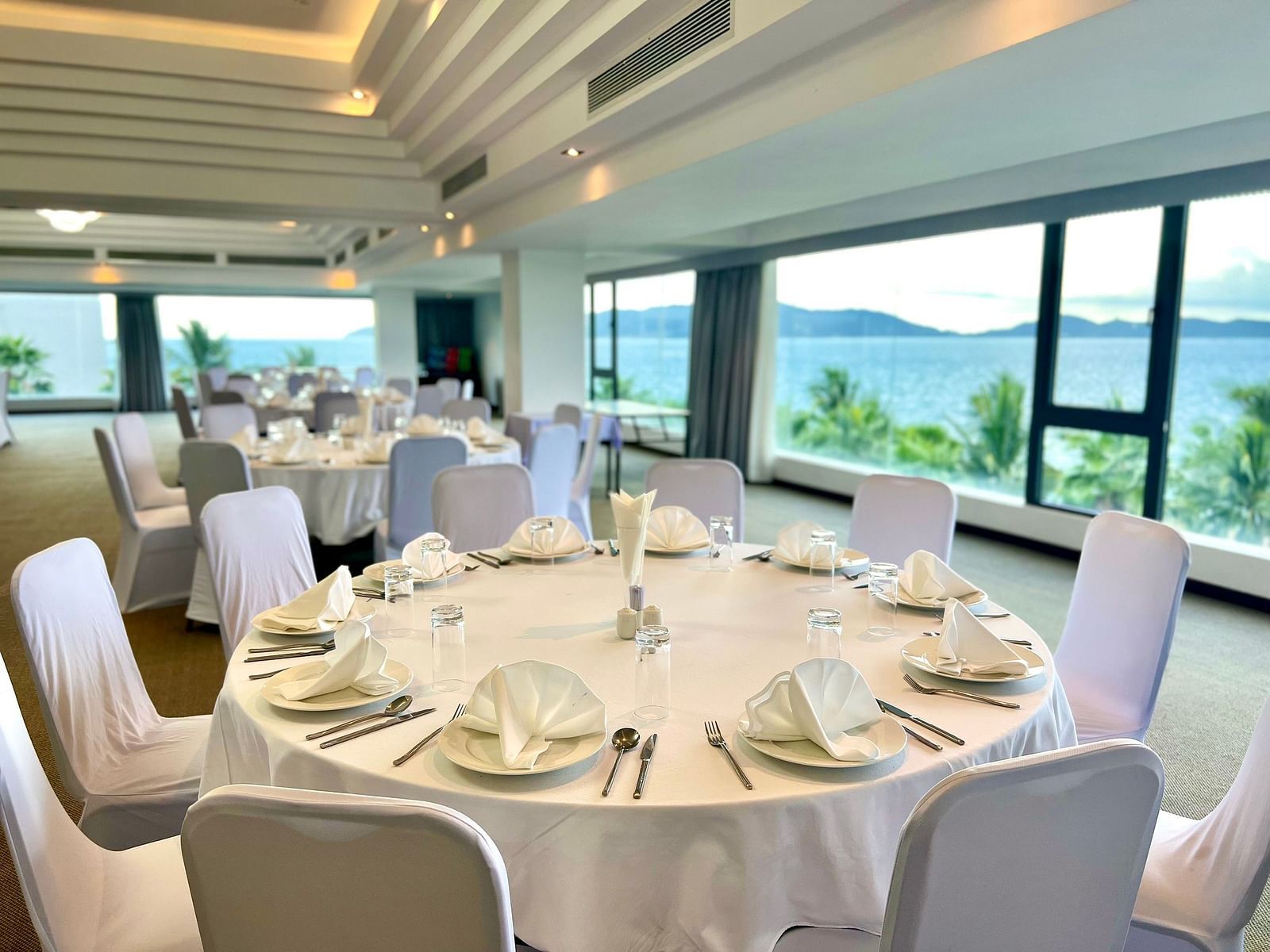 A round table with white chairs surrounding it in our Panorama Hall - Alibu Resort 