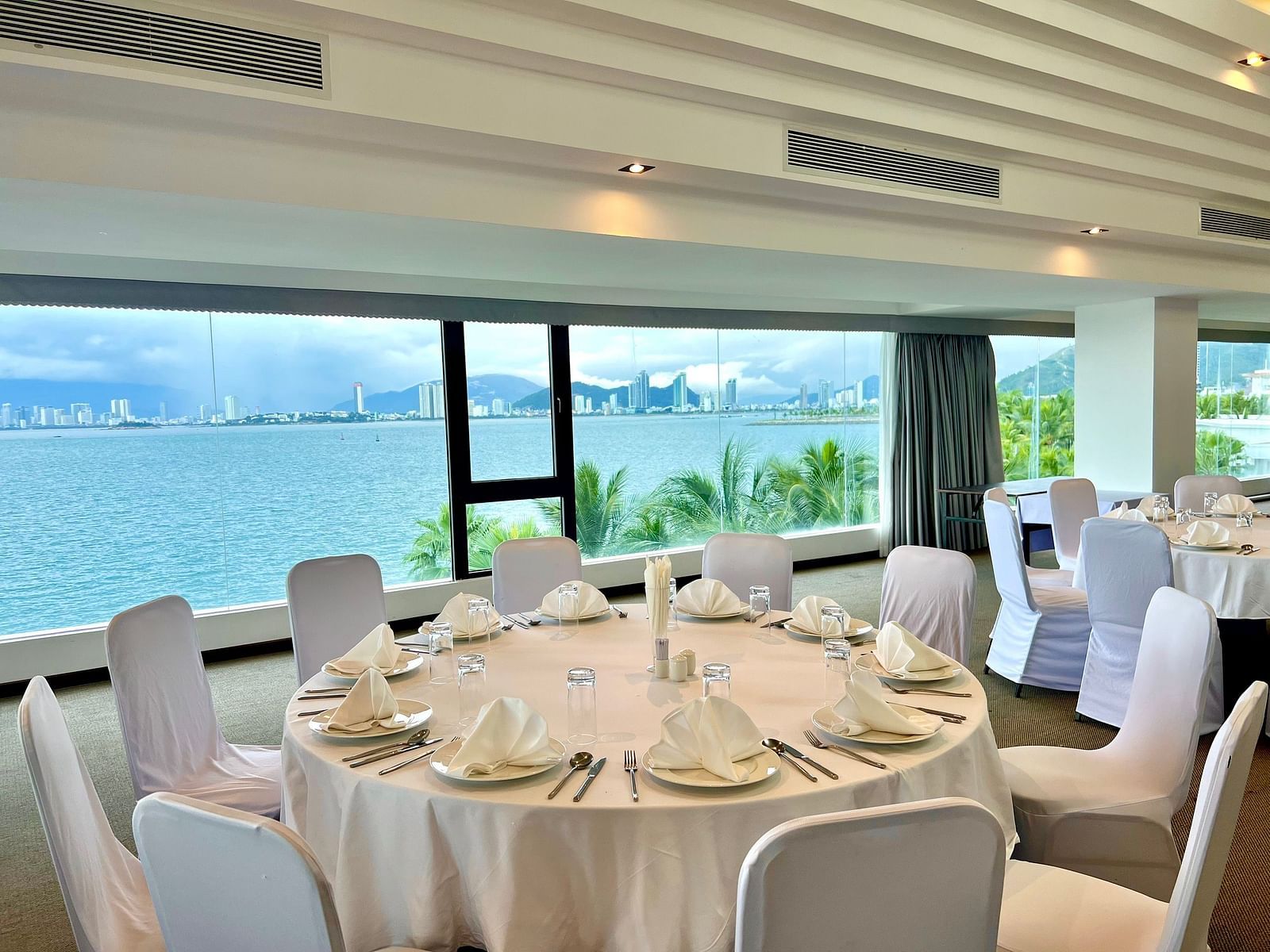 A high angle shot of our Panorama meeting hall with round tables and comfortable chairs - Alibu Resort