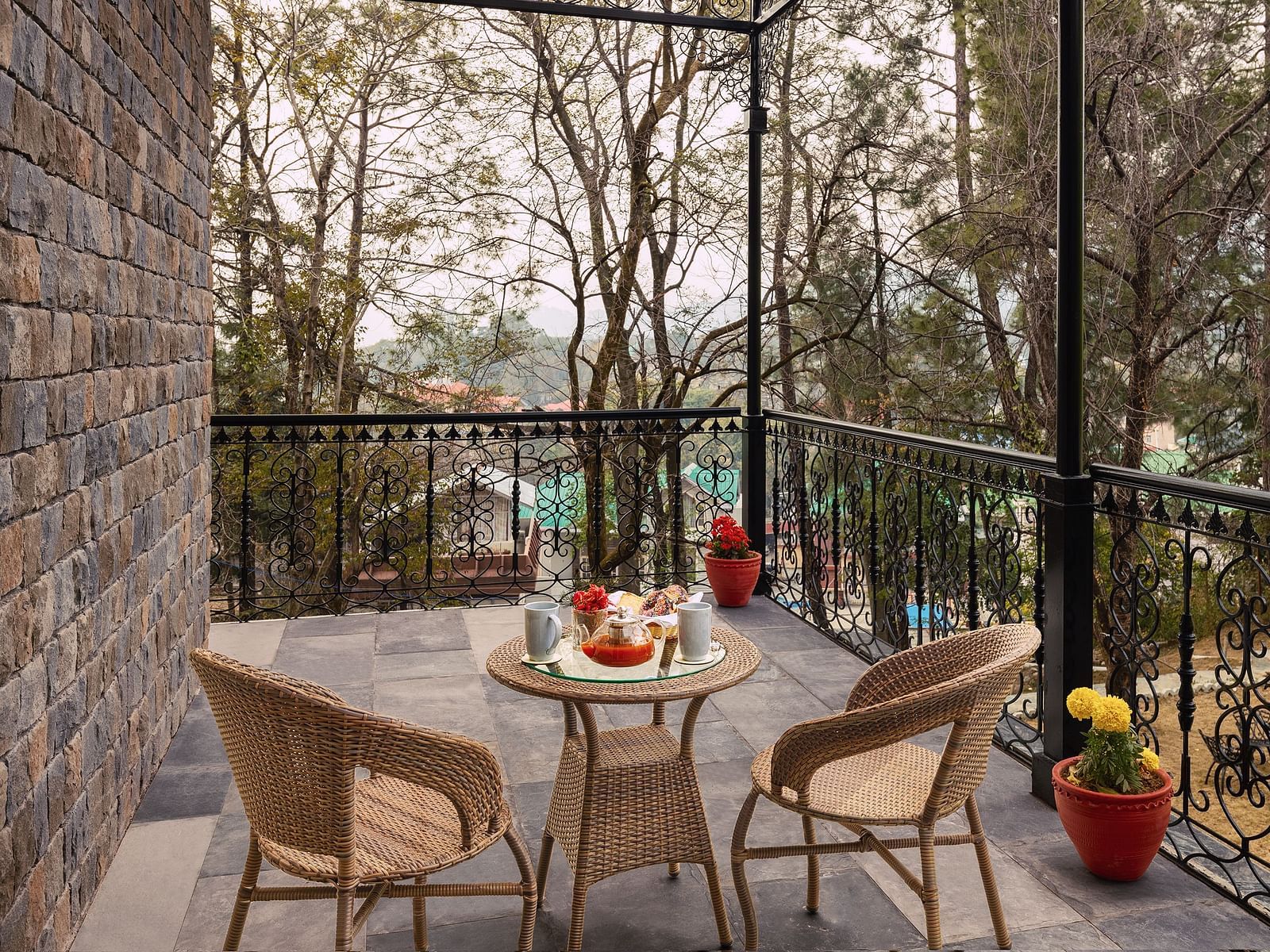 A coffee table and chairs in a balcony at INFINITEA Dak Bungalow, Palampur