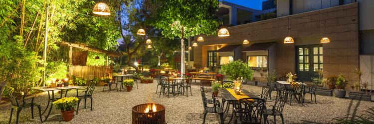 outdoor seating at under the neem - Karma Lakelands.