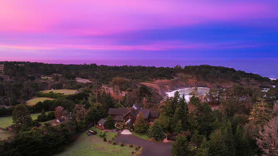 A scenic aerial view showing the hotel grounds surrounded by lush trees and a vast expanse of nature - Brewery Gulch Inn & Spa