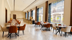 Pride Premier Alwar | A dining space with chairs and tables in a pathway.
