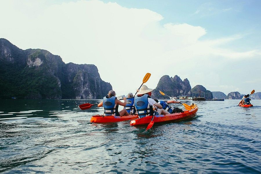 A group of people on a water body rafting in separate rafts.