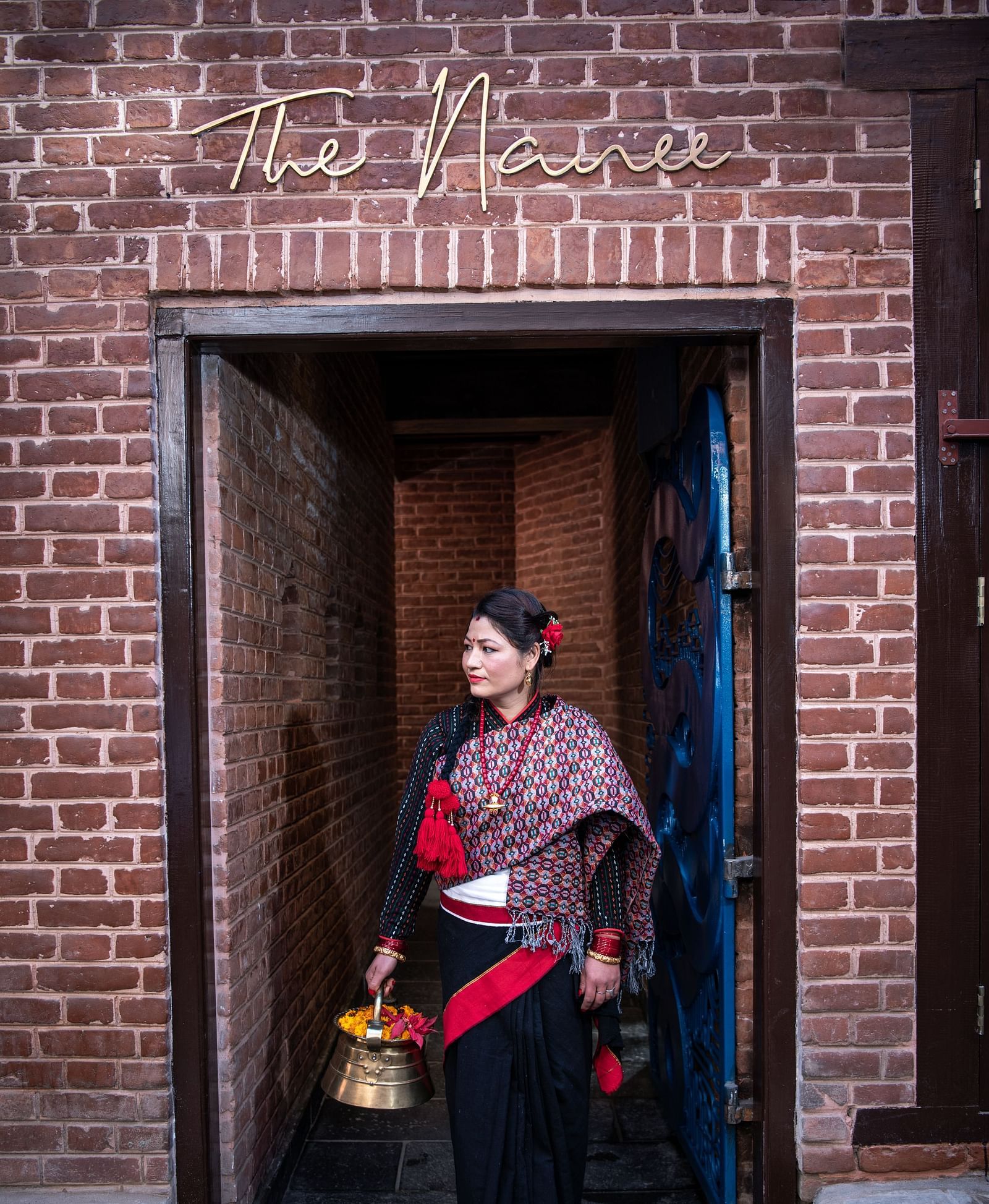 A women wearing the traditional Nepali attire standing at the Street Entrance of The Nanee