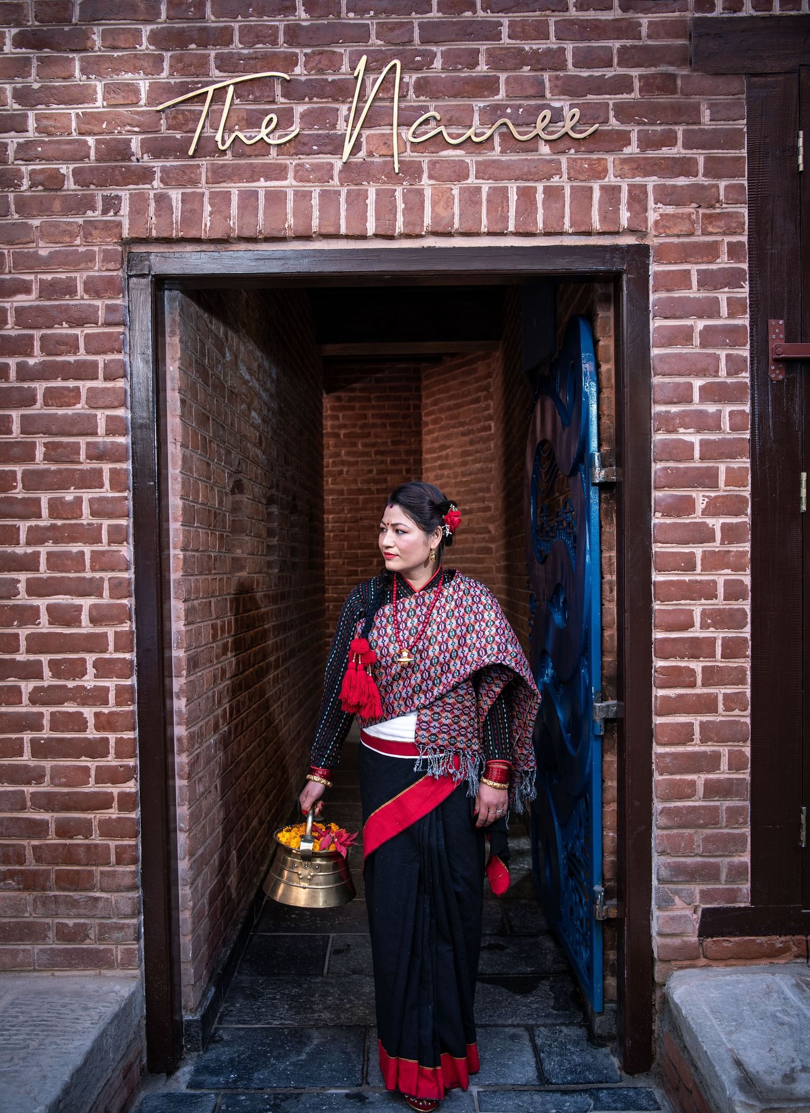 A women wearing the traditional Nepali attire standing at the Street Entrance of The Nanee