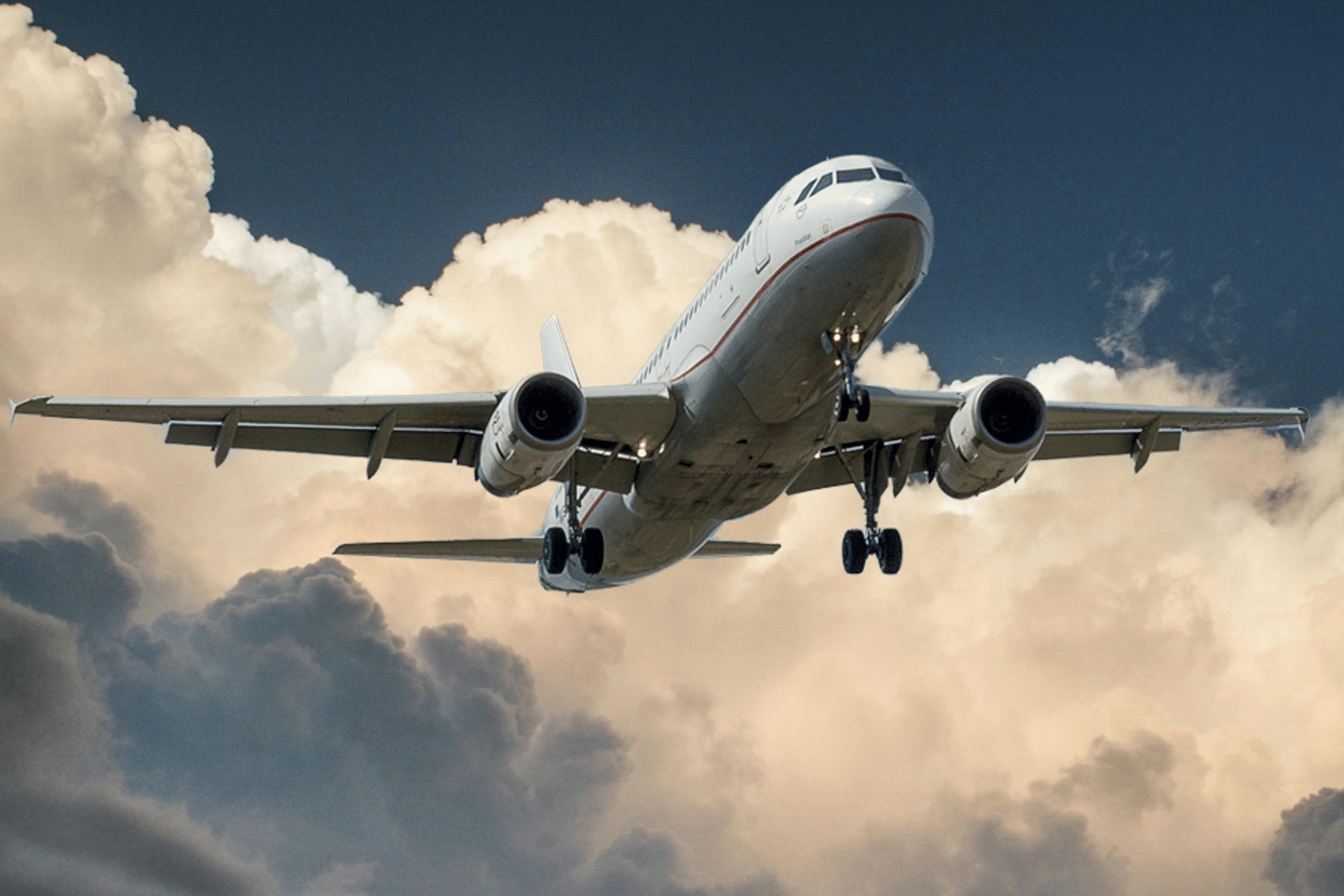 An aeroplane soaring against a cloudy sky.