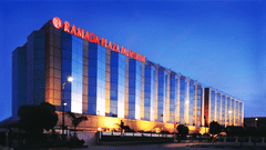 Facade view during twilight with the lights on and signage lit - Hotel Ramada Plaza Palm Grove