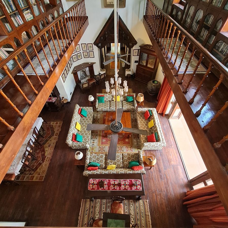 A colorful living room with a high ceiling and a balcony.