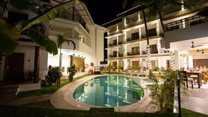 The night view of the verda de miranda resort with swimming pool, tall buildings and trees.