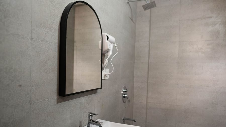 Image of a sink and a glass mounted on the wall at the 1 bhk Executive Studio Apartment, Vistar Holidays, Goa.