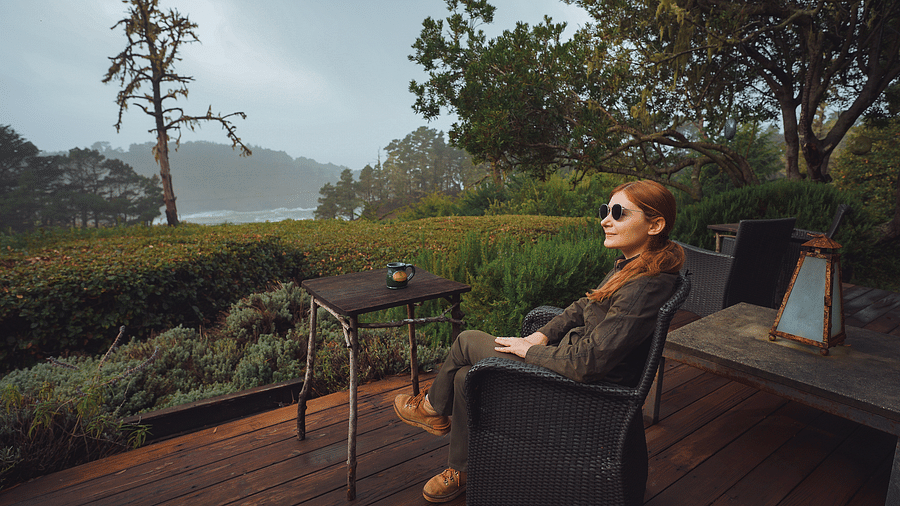 A guest enjoying a serene view while sitting in a comfortable chair, surrounded by nature - Brewery Gulch Inn & Spa