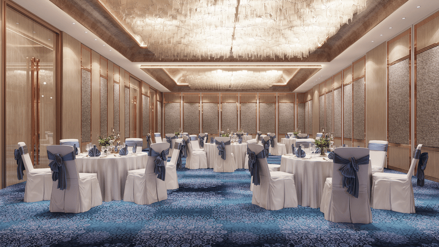 Interior view of a large ballroom or event space with round tables set with white linens and blue chair covers at Ramada Encore by Wyndham, the best hotel in Chandigarh.
