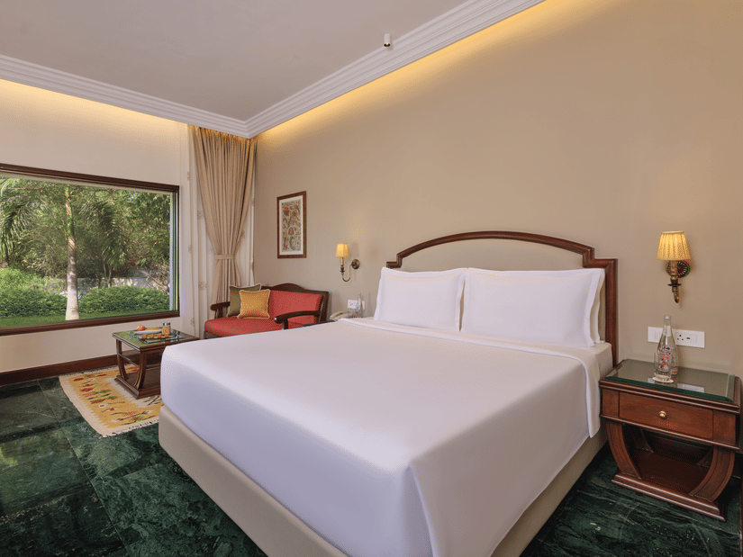 The Premium King Garden View Room at The Ummed Ahmedabad features a plush king size bed, elegant decor, and a scenic garden view