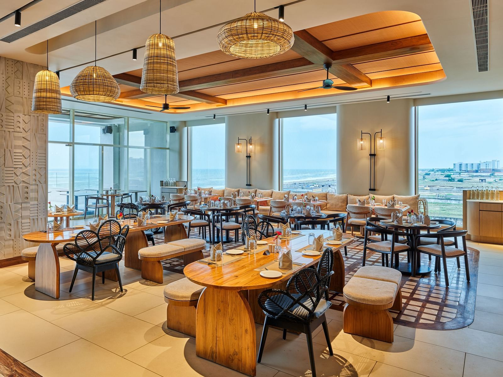 Image of Beach Hut Restaurant at Swosti Premium Beach Resorts in Puri under ambient lighting with large windows and extensive sitting area