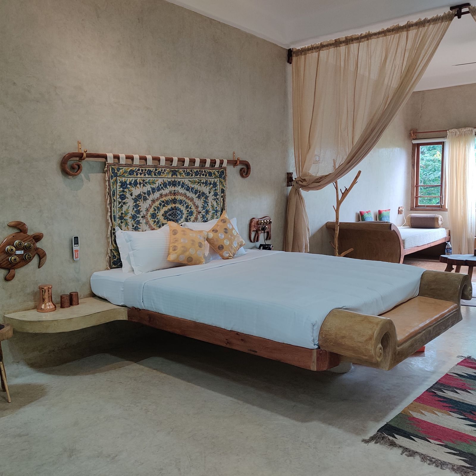 Close up view of the bed in snapper room with beautiful seating space attached to the bed, and contemporary beddings make the room pleasing and opulent.