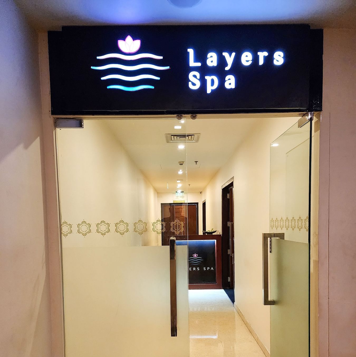 Layers Spa- Entrance Glass Door with Warm white lighting inside and Name on the above
