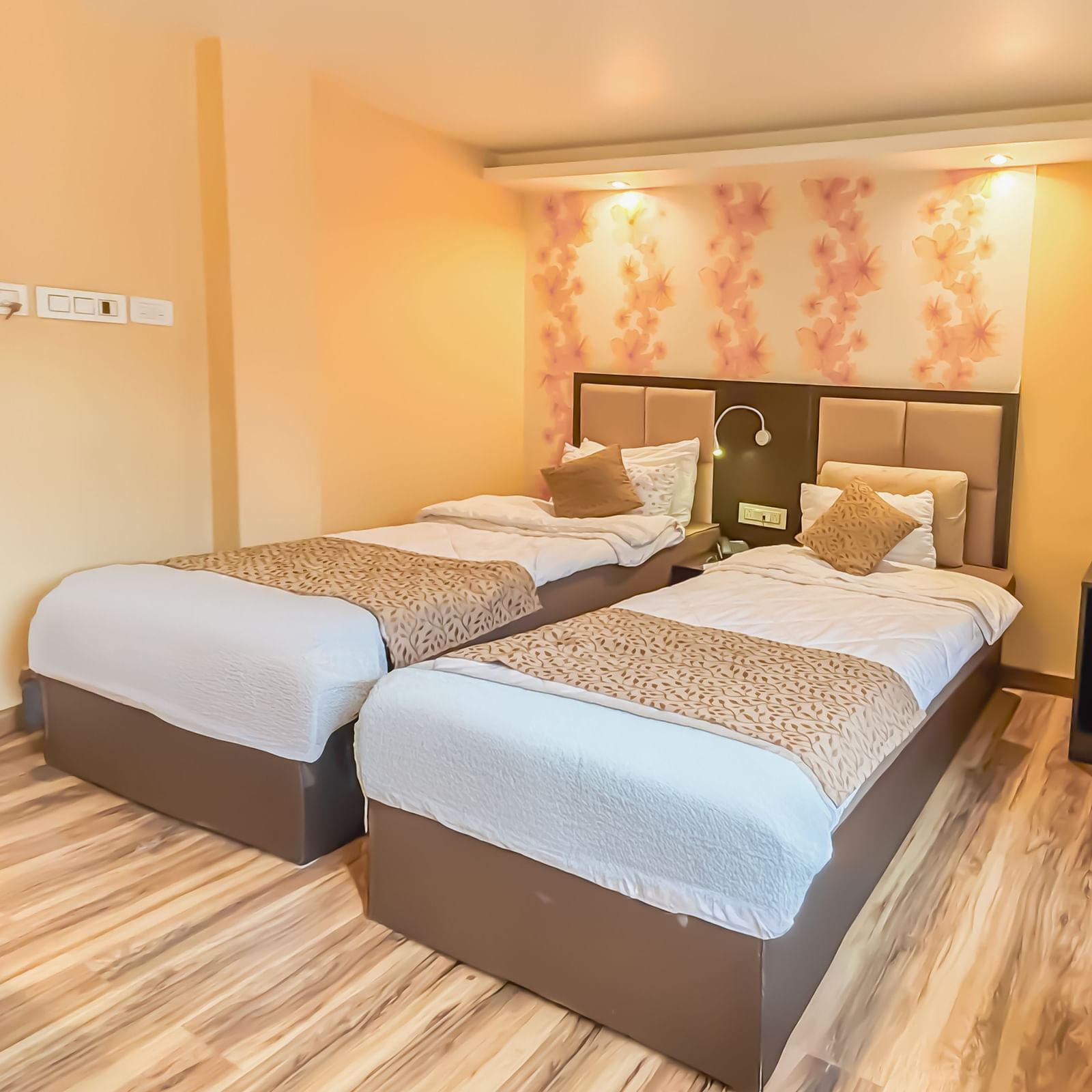 Twin beds with a decorative painting behind the headboard at Avianna Hungry Jack, Gangtok.