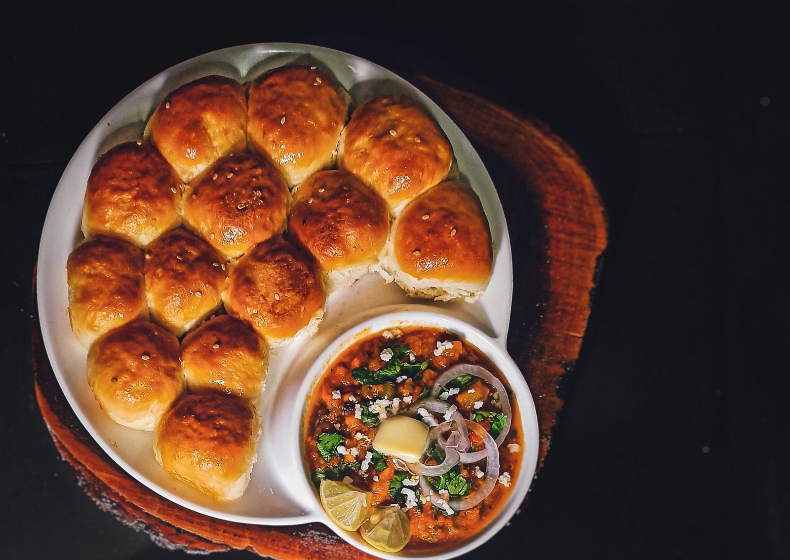 An aerial view of a maharastrian dish with bread and sides kept on top of a table.