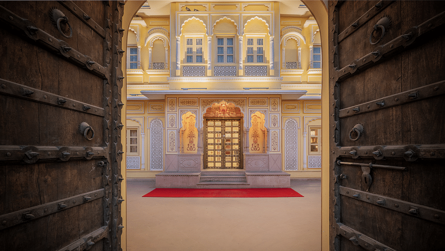 a rustic wooden door opening into the courtyard featuring a beautiful entrance - Brij Castle, Jaipur