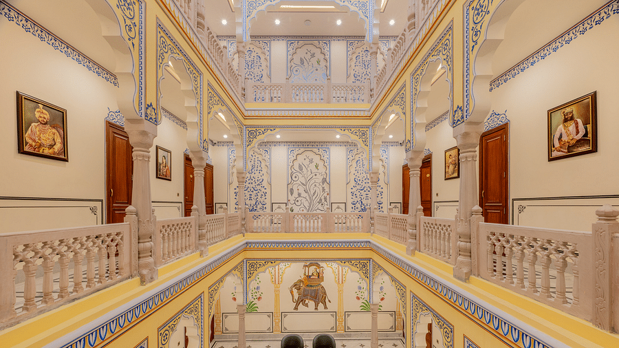 full view image of the corridor with beautiful miniature style painting done on the side walls and pillars of the first level - Brij Castle, Jaipur