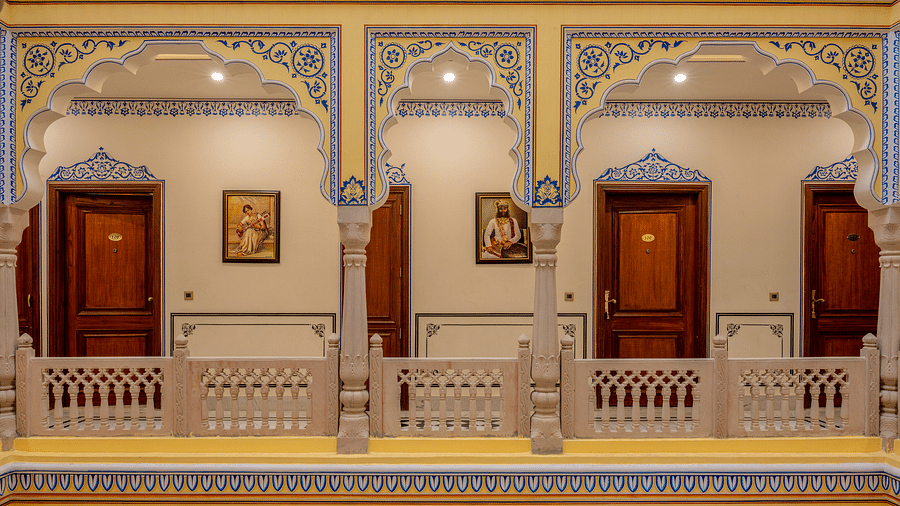 a beautiful corridor with pillars painted in miniature style painting - Brij Castle, Jaipur