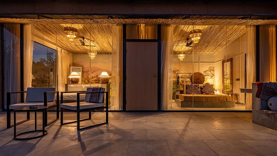 A facade image of a room with bright decorative lighting with outdoor seating arrangement - Utsav Camp Sariska